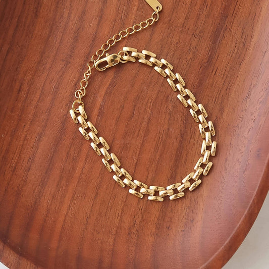 Gold chain bracelet on a wooden surface