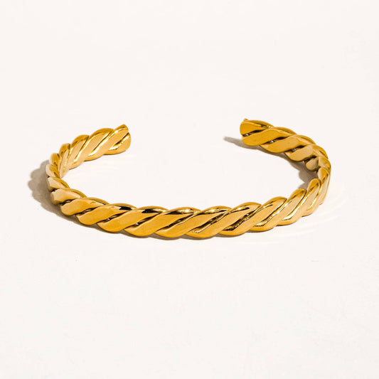 Gold braided bracelet on a white background