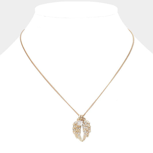 Gold necklace with a leaf-shaped pendant on a mannequin.